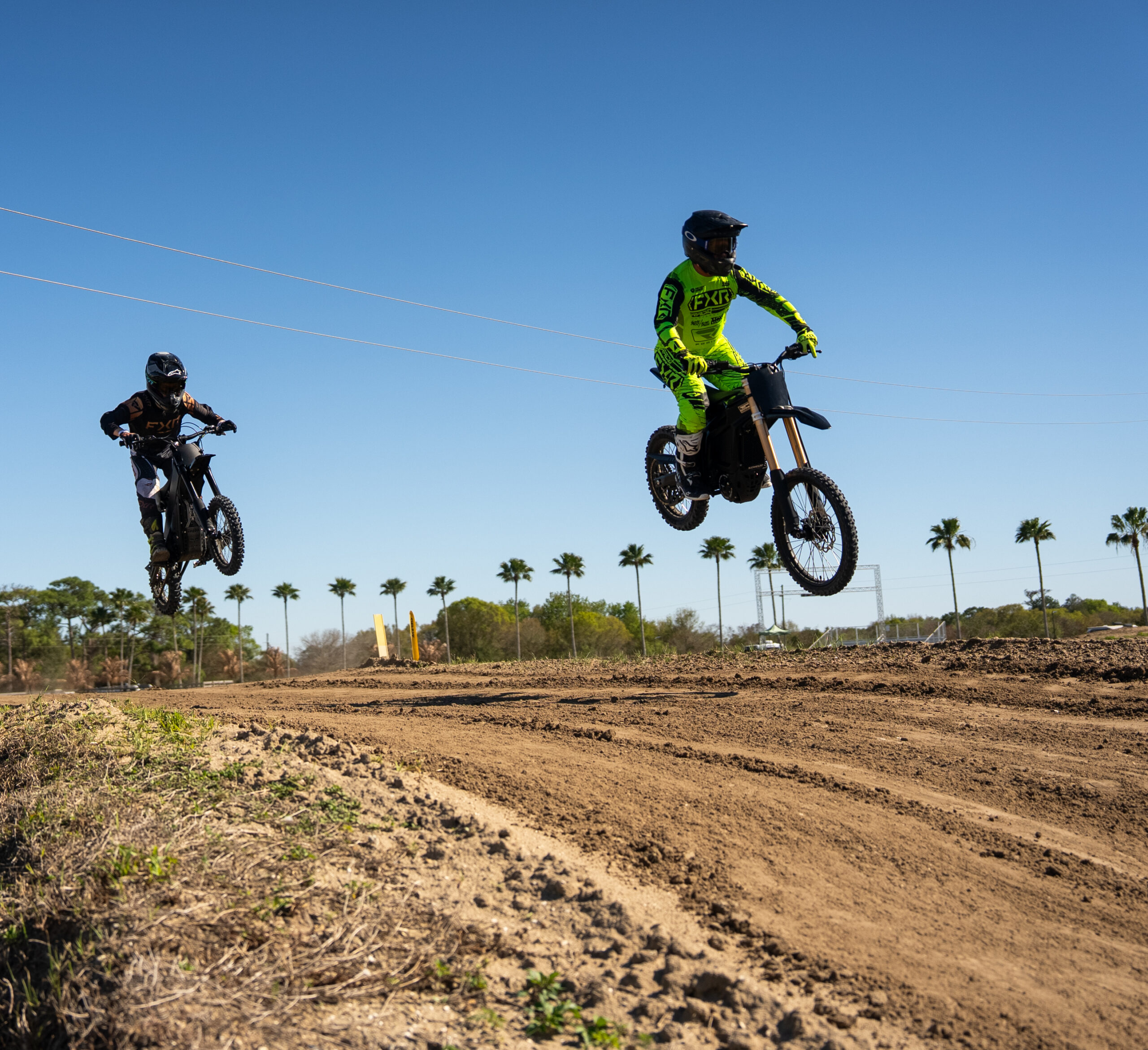 Talaria riders above a sunlit dirt track